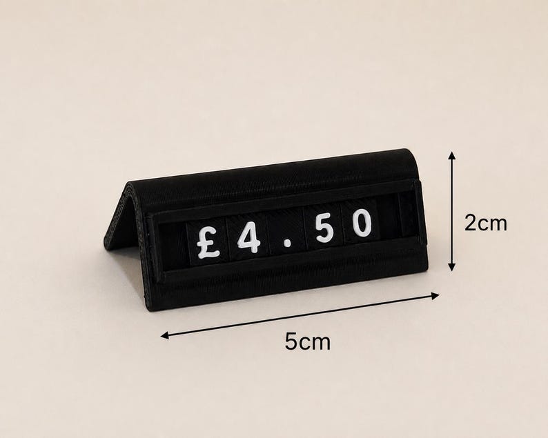 May include: A black triangular price tag display stand featuring white characters that read &pound; 4.50. The stand measures 5 cm in length and 2 cm in height as indicated by the black arrows and text labels printed on the image for reference.