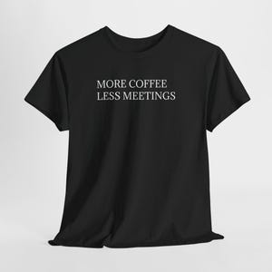 Può includere: T-shirt nero con la scritta bianca "MORE COFFEE LESS MEETINGS" centrata sul davanti. La maglietta a maniche corte è realizzata in un materiale morbido ed è adatta per l'abbigliamento casual. La maglietta è a girocollo.