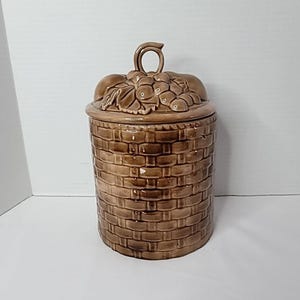 Tarro vintage marrón tejido con frutas y margaritas, hecho a mano y firmado, 1975.