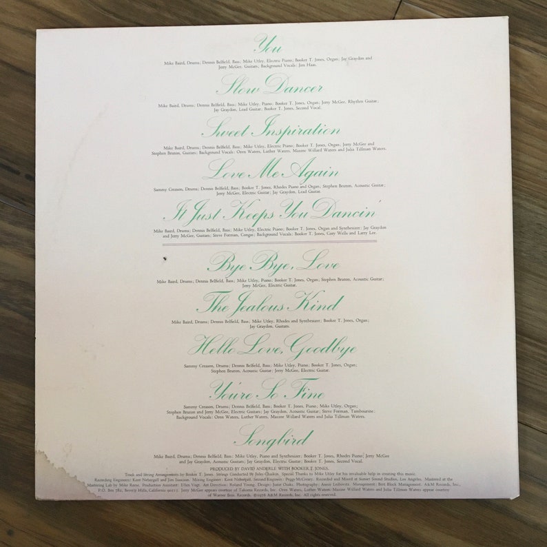May include: A vintage vinyl record album cover with a green and white color scheme. The album cover features the title "Songbird" and a list of songs, including "Yu", "Slow Dancer", "Sweet Inspiration", "Love Me Again", "In Just Keeps You Dancin", "Bye Bye, Love", "The Jealous Kind", "Hello Love, Goodbye", "You're So Fine", and "Songbird".
