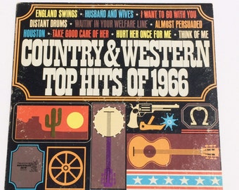May include: Vintage vinyl record album cover for "Country & Western Top Hits of 1966." The cover is black with orange and white text. It features illustrations of a desert scene, banjo, guitar, and a revolver.