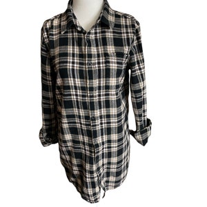 May include: A black and white plaid flannel shirt with long sleeves and a button-up front.