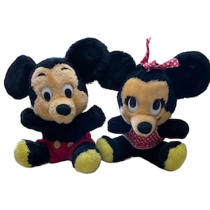 May include: A pair of vintage plush Mickey Mouse and Minnie Mouse toys. Mickey is wearing red shorts and Minnie is wearing a red and white polka dot dress. Both have large black eyes and black ears.
