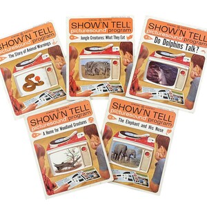 May include: Five vintage General Electric Show 'n Tell picturesound program record covers. The covers feature colorful illustrations of animals and the titles "The Story of Animal Warnings", "Jungle Creatures: What They Eat", "Do Dolphins Talk?", "A Home for Woodland Creatures", and "The Elephant and His Nose".