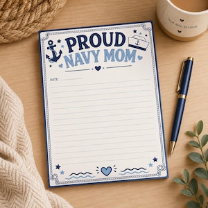 May include: A rectangular notepad with a white background and a dark blue rope border. The top features the text PROUD NAVY MOM in blue and dark blue, with an anchor, a sailor hat, and small hearts. The page includes a date line and horizontal lines.