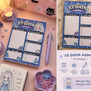 May include: A blue Ice Queen Agenda notepad with a cartoon illustration. The notepad features sections for to-do lists, brain freeze, chill zone, time block, and self-care spells. A purple pen rests beside the notepad. The notepad is 5x7 inches.