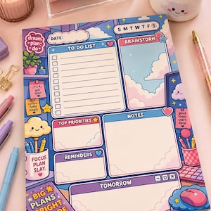May include: A daily planner notepad featuring a pastel blue and purple sky theme with clouds. The layout includes sections for a to-do list, brainstorm, top priorities, notes, reminders, and tomorrow, with text like dream plan do and big plans bright future.