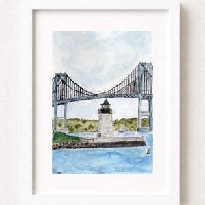 May include: A framed watercolour painting depicting a stone lighthouse situated on a rocky shore beneath a large steel suspension bridge. The scene includes blue water, green trees in the background, and a small sailboat, with the initials JMF in the corner.