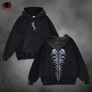 May include: Black hooded sweatshirt with a front pocket and a holographic design. The front features a small symbol, while the back displays a larger, intricate pattern. The sweatshirt has a washed, vintage look.