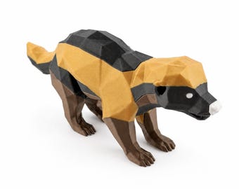 Puede incluir: Una figura geométrica low-poly de un tejón de miel con un diseño de bloques de color negro, bronceado y marrón oscuro. El animal tiene una nariz blanca y ojos blancos. Una pequeña etiqueta rectangular morada muestra el texto HoneyBadger Crypto.