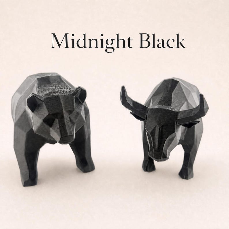 A black geometric bear and a black geometric bull statue stand side-by-side on a light background, with the text "Midnight Black" above them.