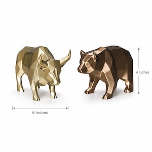 A gold geometric bull and a bronze geometric bear statue are shown with measurement lines indicating the bull is 6 inches long and both are 4 inches tall.