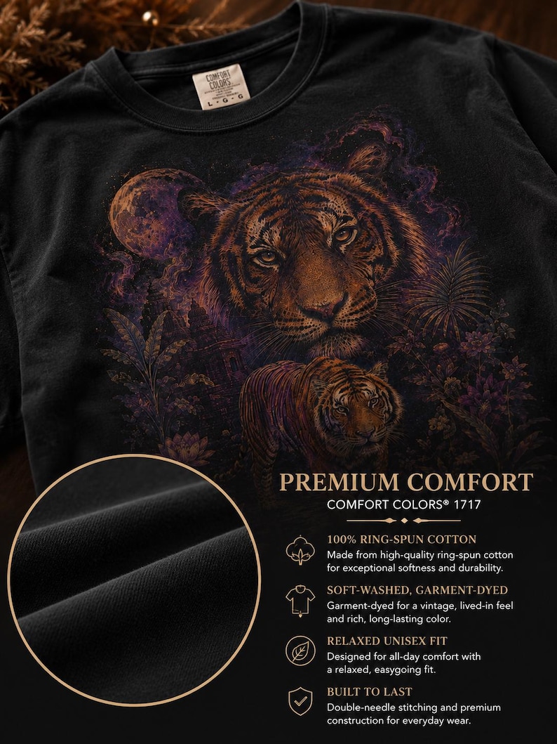 May include: A black t-shirt featuring a graphic print of two tigers in a jungle setting with a moon. The shirt includes text reading PREMIUM COMFORT, COMFORT COLORS 1717, 100% RING-SPUN COTTON, SOFT-WASHED, GARMENT-DYED, RELAXED UNISEX FIT, and BUILT TO LAST.