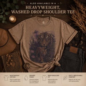 May include: A brown, heavyweight, washed drop shoulder t-shirt featuring a graphic print of a tiger in a jungle setting with a moon. The text reads: Also available in a heavyweight, washed drop shoulder tee, heavyweight cotton, washed finish.