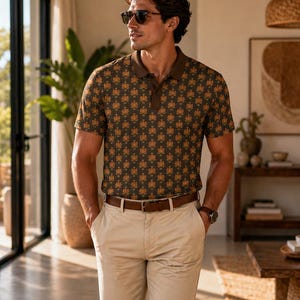 May include: A short-sleeved polo shirt with a brown collar and a repeating floral pattern in shades of brown and gold. The shirt is paired with khaki pants and a brown leather belt. The person is also wearing sunglasses and a watch.