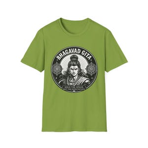 May include: Green t-shirt featuring a circular graphic with the text "BHAGAVAD GITA" and an illustration of a figure. The graphic also includes the text "HOLD THE SPEAR, NOT THE EXPECTATION".