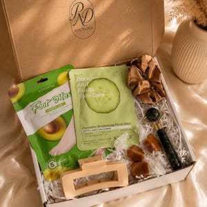 Peut inclure: Un coffret cadeau contenant un masque pour les pieds &agrave; l'avocat Kormesic, un masque facial hydratant au concombre Botany and Fruits, un chouchou en satin beige, un rouleau facial en jade vert fonc&eacute; et une pince &agrave; cheveux rectangulaire mate.