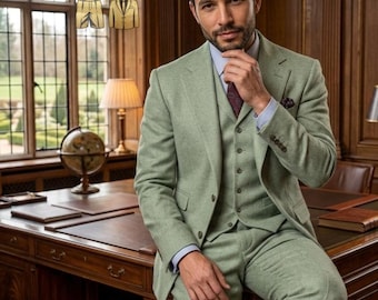 Op de afbeelding: Een lichtgroen driedelig pak bestaande uit een blazer, een vest met knopen en een bijpassende broek. Het pak wordt gedragen over een lichtblauw overhemd met kraag, een donkere das met patroon en een pochet. De tekst THEGENTISER is bovenaan zichtbaar.