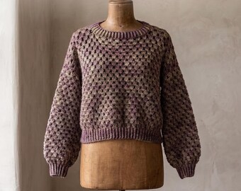 Könnte beinhalten: Ein bauchfreier Pullover mit strukturiertem Häkelmuster in verschiedenen Violett- und Brauntönen. Das Kleidungsstück hat lange Ärmel mit gerippten Bündchen und einen Rundhalsausschnitt. Text: Hazel Cropped Sweater Crochet Pattern. Instant PDF Download.