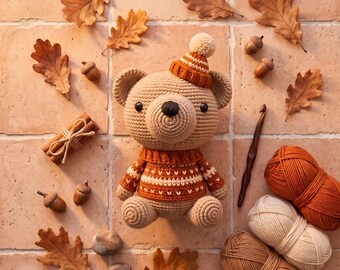 Könnte beinhalten: Ein gehäkelter Bär mit einem beige-orangen Pullover und einer passenden Mütze mit Bommel. Der Text lautet Crochet Classic Amigurumi Bear Plushie Pattern und Instant PDF Download. Enthält Garn, eine Häkelnadel und Eicheln.