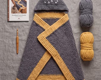 Könnte beinhalten: Eine gehäkelte Kapuzendecke für Babys mit grau-senfgelbem Design und Tierohren an der Kapuze. Enthält eine gedruckte Anleitung, eine Holzhäkelnadel, zwei Garnknäuel und eine Metallschere. Text: Crochet Knit Hooded Baby Blanket Pattern, Woodland Fawn Hoodie, Instant PDF Download.