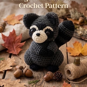 May include: A dark grey and cream crocheted raccoon amigurumi with black accents, featuring the text Amigurumi Raccoon Crochet Pattern and Instant PDF Download. The raccoon has a striped tail, dark eyes, and a round snout, crafted with yarn.