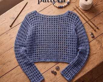 Könnte beinhalten: Ein blaues, langärmeliges Häkeloberteil mit Netzmuster und weitem Ausschnitt. Das Bild enthält den Text Crochet Mesh Top pattern und Instant PDF Download sowie Holzstricknadeln, ein Garnknäuel, Holzperlen und kleine Knöpfe.