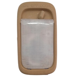 May include: Tan car interior light fitting with a rectangular, textured, clear plastic lens. The fitting has a tan frame with the words "ON OFF DOOR" printed on the top. A small tan switch is located above the lens.