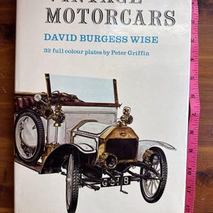 May include: A vintage book titled "VINTAGE MOTORCARS" by David Burgess Wise, featuring 32 full-color plates by Peter Griffin. The cover displays an illustration of a classic car. The book is approximately 12 inches tall.