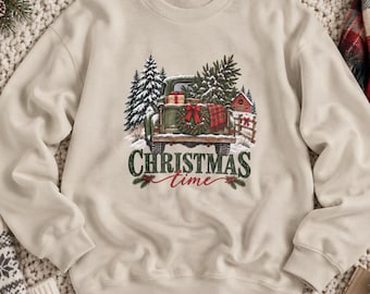 May include: A beige crewneck sweatshirt featuring a graphic of a vintage green truck carrying a Christmas tree and gifts. The text "CHRISTMAS time" is printed below the truck in dark green and red script lettering.