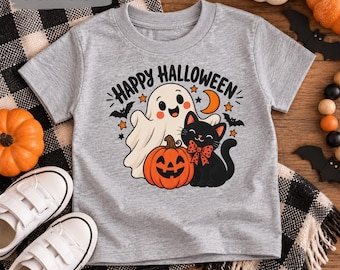 May include: A sport grey short-sleeve t-shirt featuring a graphic print of a smiling ghost, a black cat with a red polka dot bow, and a jack-o'-lantern. The text "HAPPY HALLOWEEN" is printed in black above the characters, accompanied by stars and a crescent moon.