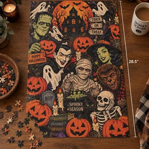May include: A rectangular Halloween-themed jigsaw puzzle measuring 19 inches by 28.5 inches. The illustration features Frankenstein, a vampire, a mummy, a werewolf, a skeleton, ghosts, pumpkins, a haunted house, and text reading Spooky Season.