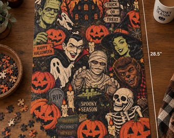 May include: A rectangular Halloween-themed jigsaw puzzle measuring 19 inches by 28.5 inches. The illustration features Frankenstein, a vampire, a mummy, a werewolf, a skeleton, ghosts, pumpkins, a haunted house, and text reading Spooky Season.