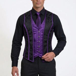 Op de afbeelding: Een zwart vest met een paarse satijnen voorkant en bies. Het vest heeft een bloemenpatroon en wordt gedragen over een zwart shirt met lange mouwen en een paarse stropdas. De persoon draagt ook een zwarte krijtstreepbroek.