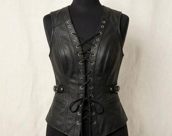 May include: Black leather vest with a V-neck and lace-up front. The vest features metal grommets, adjustable buckles, and a tailored fit. A stylish and edgy garment for layering.
