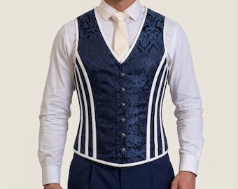 May include: A dark blue brocade vest featuring a V-neckline, a front button closure, and white piping accents along the sides. The vest is worn over a crisp white long-sleeved button-down shirt with a light-colored necktie and dark blue trousers.