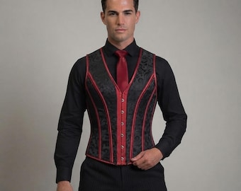 May include: A black corset vest featuring a dark floral brocade pattern with vibrant red piping along the seams and front closure. The vest includes a central row of silver-toned metal hooks for fastening, worn over a black long-sleeve shirt.