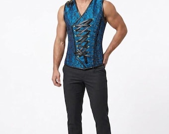 May include: A sleeveless blue corset vest featuring a black floral brocade pattern, a V-neckline, and a front lace-up closure with black cord. The garment is paired with solid black trousers and brown leather shoes, creating a structured ensemble.
