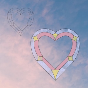 May include: Two heart-shaped stained glass designs. One is a line drawing, the other is a finished piece. The finished heart features a pink centre, yellow accents, and a clear border, set against a sky background.