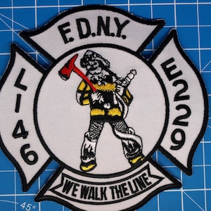 May include: Embroidered patch featuring a firefighter in a Maltese cross design. The patch includes the text "E.D.N.Y.", "L-46", "E229", and "WE WALK THE LINE". The firefighter is holding a red axe and a hose.