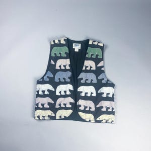 May include: A black vest adorned with a repeating pattern of colorful polar bear appliqués. The bears are in shades of green, blue, white, and pink. The vest has a V-neck and a label at the back of the neck.