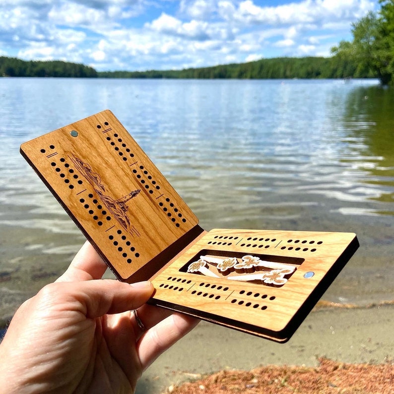 Travel cribbage board opened and lake view in background
