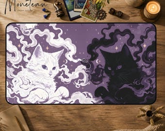 May include: A rectangular desk mat featuring a purple background with a white cat on the left and a black cat on the right, both surrounded by swirling smoke and small stars. The design includes crescent moon motifs and a dark, mystical aesthetic.