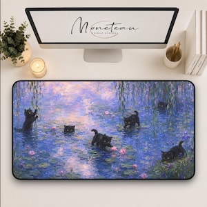 May include: A rectangular desk mat featuring an impressionist-style painting of five black kittens playing in a pond filled with blue water, green lily pads, and pink water lilies, with weeping willow branches hanging over the water surface.