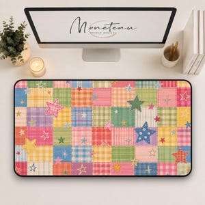 May include: A rectangular desk mat featuring a colorful patchwork quilt pattern of various plaid and checkered squares in shades of pink, blue, yellow, orange, and green, decorated with scattered star shapes in different sizes and colors.