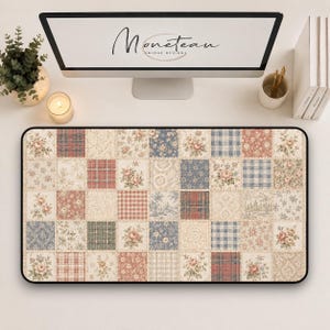 May include: A rectangular desk mat featuring a patchwork design of various square patterns including floral prints, red and blue plaid, and damask motifs in muted tones of cream, dusty rose, sage green, and slate blue with a black border.
