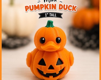 May include: A small orange duck-shaped figure with a pumpkin-like body and a green stem on its head. The front features a carved jack-o'-lantern face with black triangular eyes and a jagged mouth. Text above reads Mini PUMPKIN DUCK 1" TALL.
