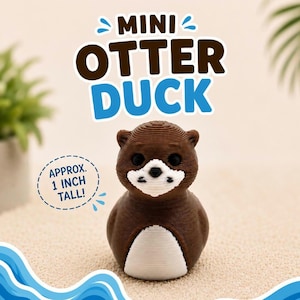 Puede incluir: Una peque&ntilde;a figura con forma de nutria marr&oacute;n y blanca con ojos negros y hocico blanco. El texto superior dice MINI OTTER DUCK, y un gr&aacute;fico circular a la izquierda indica APPROX. 1 INCH TALL. La figura tiene una superficie texturizada.
