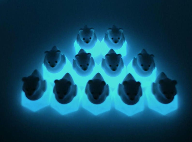 May include: A collection of ten small, white bear-shaped figurines arranged in a pyramid formation. Each bear sits atop a hexagonal base that emits a bright, glowing cyan light, creating a luminous effect against the dark background.