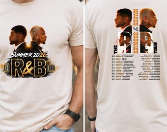May include: Beige t-shirt featuring a graphic design for "The R&B Tour Summer 2026." The front design includes two side profiles of men. The back of the shirt lists tour dates and the words "Raymond & Brown Tour."